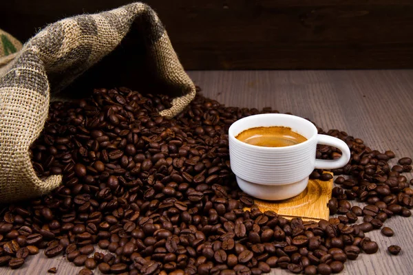 Geröstete Kaffeebohnen mit Tasse Kaffee — Stockfoto