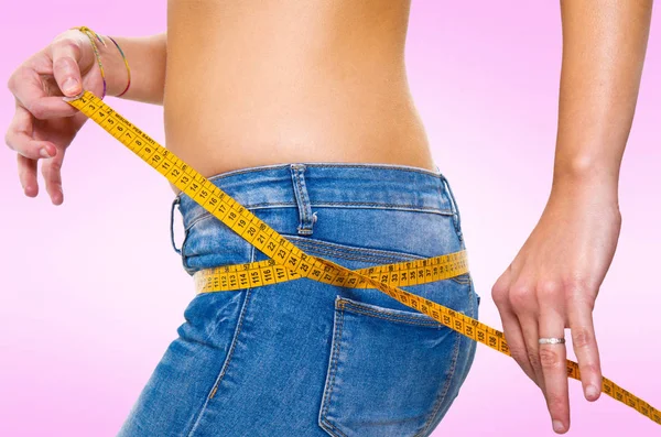 Jovem mulher medindo seu corpo — Fotografia de Stock