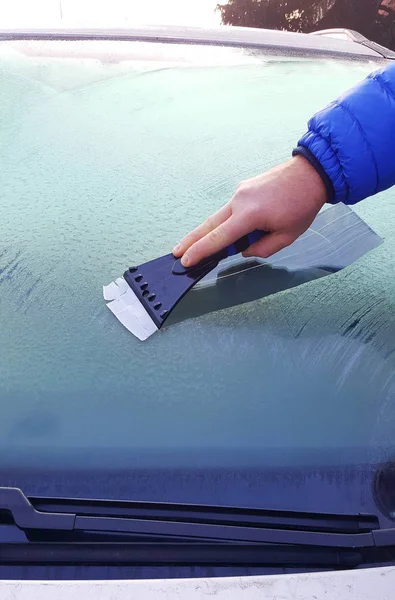 Hombre quitando hielo del parabrisas — Foto de Stock