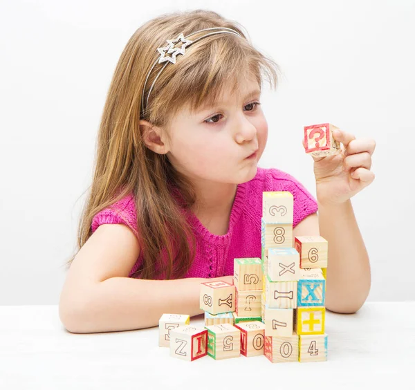 Girl playing with wooden cubes — Stock Photo, Image