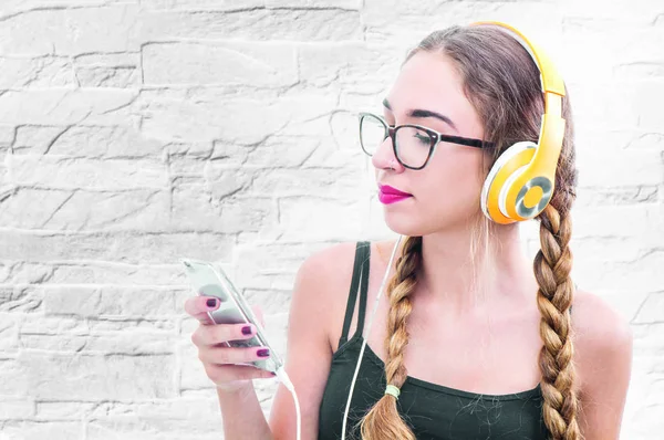 Девушка слушает музыку через смартфон и наушники — стоковое фото
