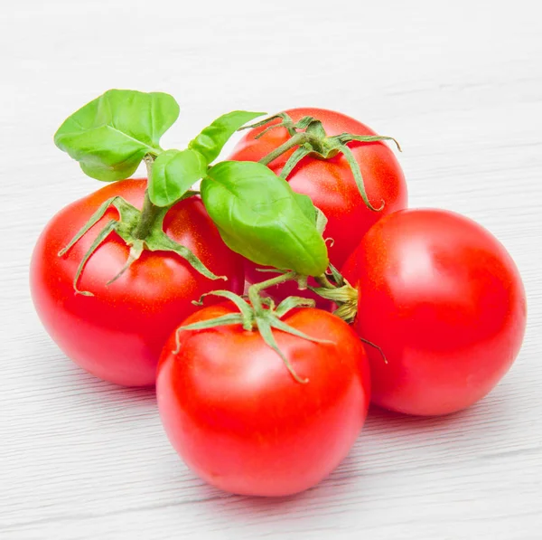 Group of fresh resd tomatoes with basil — Stock Photo, Image