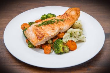 bir yatakta, brokoli, karnabahar ve havuç somon fileto