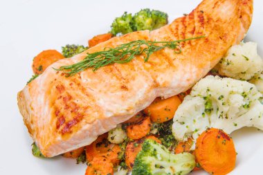 bir yatakta, brokoli, karnabahar ve havuç somon fileto