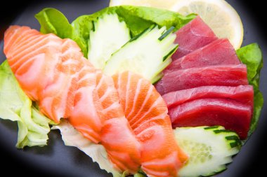 tuna and salmon sashimi on black dish clipart