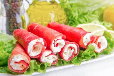 Beyaz tabakta kurutulmuş et ve peynir.