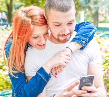 giovane coppia con cellulare al parco 
