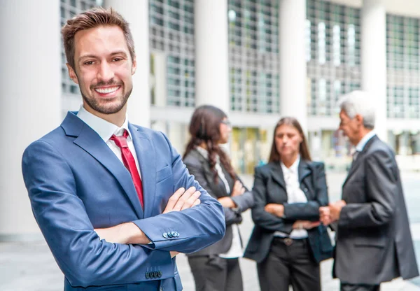 Beautiful man on the background of business people — Stock Photo, Image