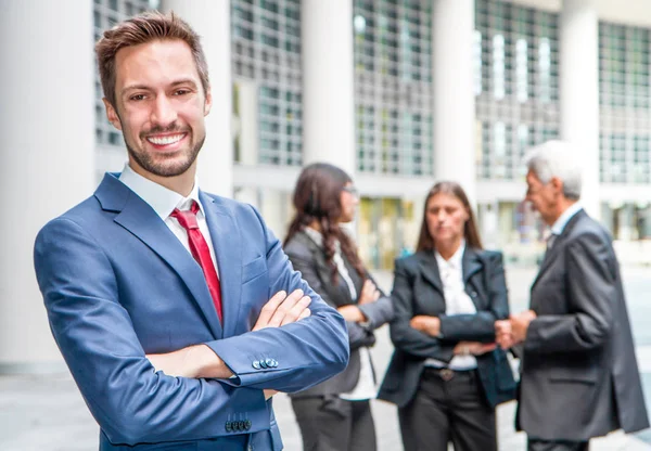 Bellissimo uomo sullo sfondo di uomini d'affari — Foto Stock