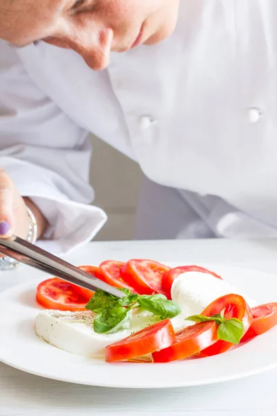 Chef professionnel préparant un plat avec tomates et mozzarella — Photo