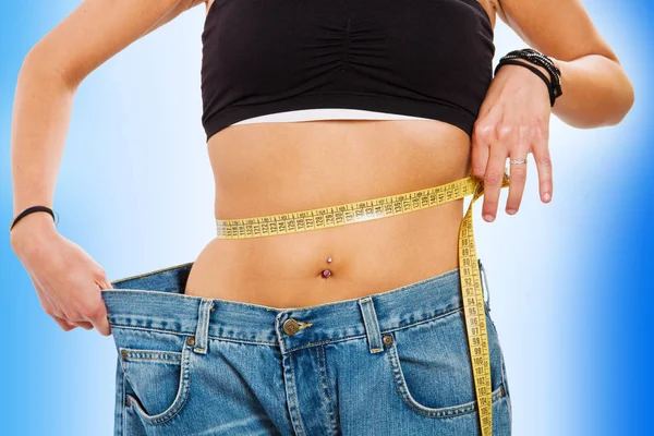 Mujer joven midiendo su cintura después de una dieta — Foto de Stock