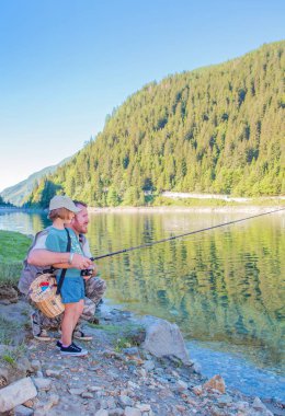 Baba ve kızı bir dağ gölü Balık tutma 