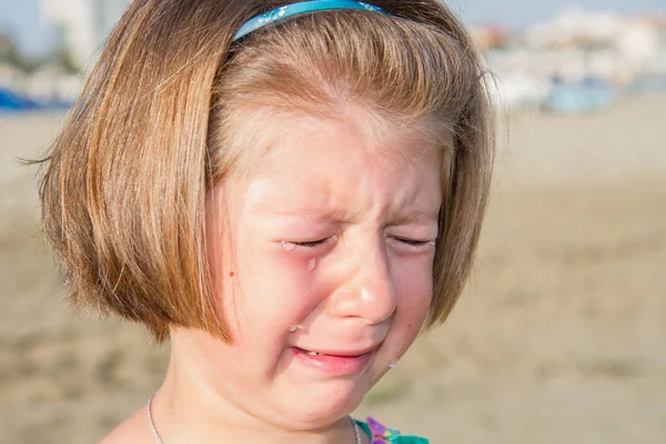 在沙滩上哭泣的小女孩 — 图库照片
