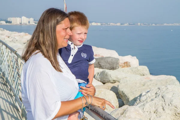 Mother and son looking into the sea — Stock Photo, Image