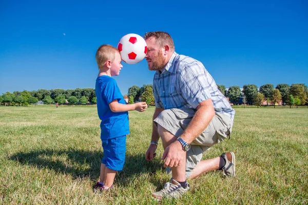 Vader en zoon spelen samen met de bal — Stockfoto
