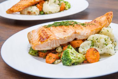 bir yatakta, brokoli, karnabahar ve havuç somon fileto