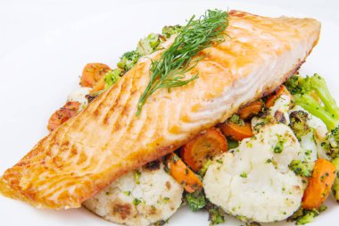 bir yatakta, brokoli, karnabahar ve havuç somon fileto