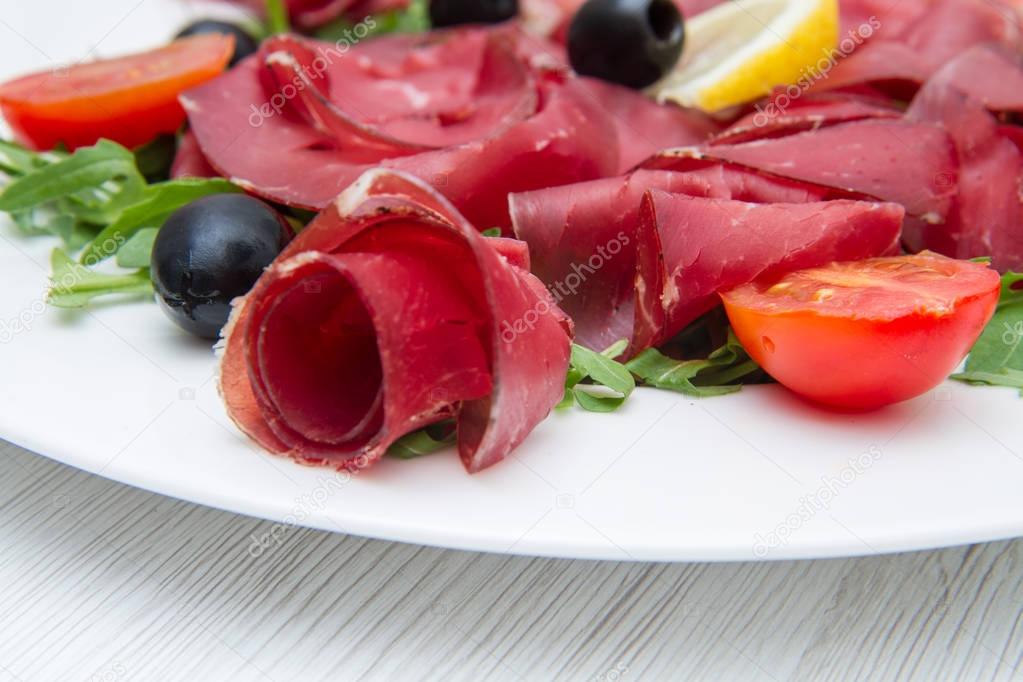 dish of bresaola and aragula