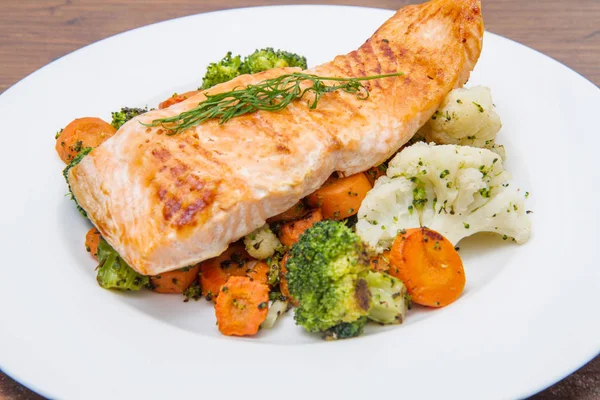 bir yatakta, brokoli, karnabahar ve havuç somon fileto