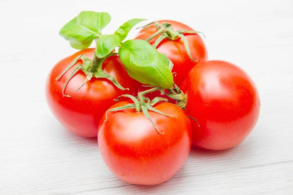 Grupp av färska resd tomater med basilika — Stockfoto