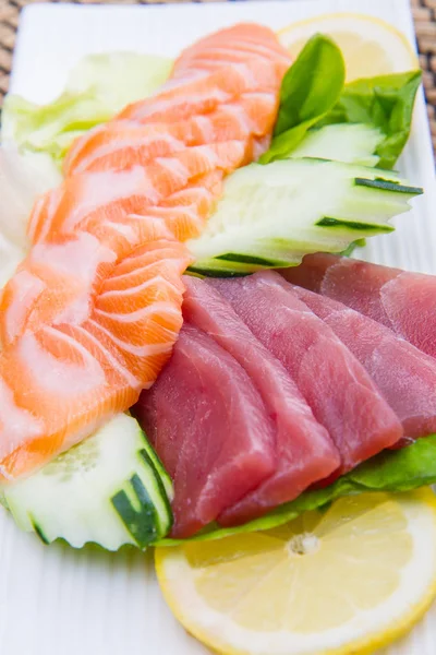 Tuna and salmon sashimi on black dish — Stock Photo, Image