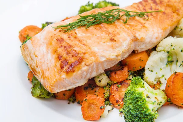 Salmon fillet on a bed of broccoli, cauliflower and carrots Royalty Free Stock Images