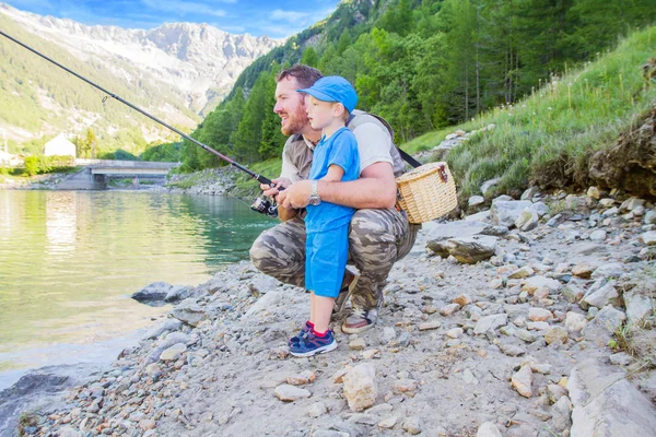 Father and son fishing in a mountain lake — Stock Photo, Image