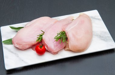 siyah ahşap masa üzerinde beyaz tabakta tavuk göğsü