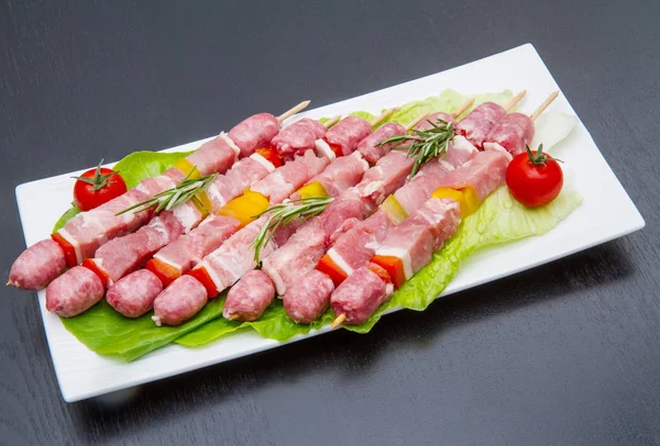 Grupo de espetos de carne na mesa de madeira preta — Fotografia de Stock