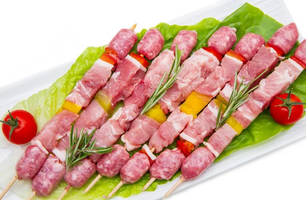 Grupo de espetos de carne em prato em fundo branco — Fotografia de Stock