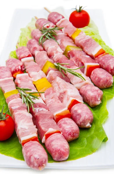 Gruppo di spiedini di carne su piatto su fondo bianco — Foto Stock