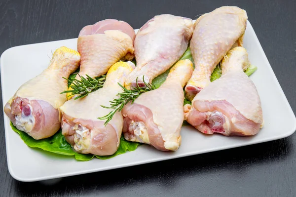 siyah ahşap masa üzerinde beyaz bir tabak tavuk uyluk