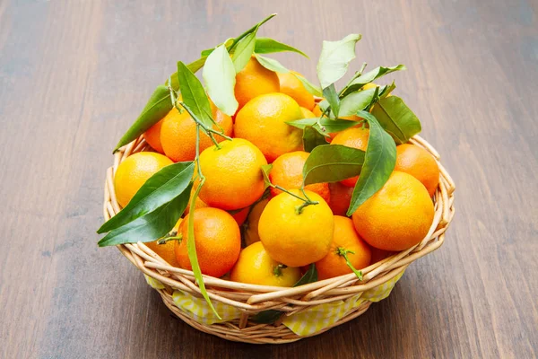 Verse mandarijn sinaasappelen fruit met bladeren op houten tafel — Stockfoto