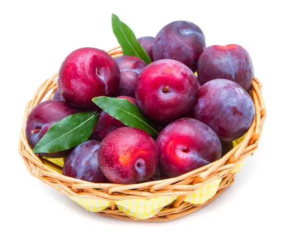 Groupe de prunes rouges dans un panier sur fond blanc — Photo