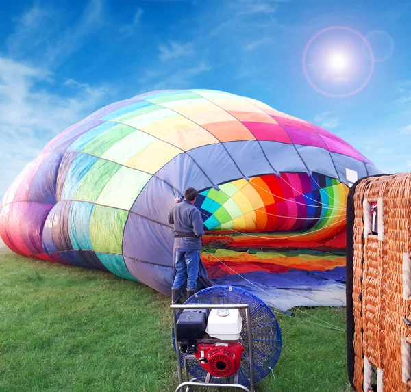 Multi gekleurde hete luchtballon in een veld — Stockfoto