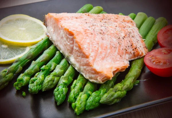 Salmon fillet on asparagus bed on dish — Stock Photo, Image