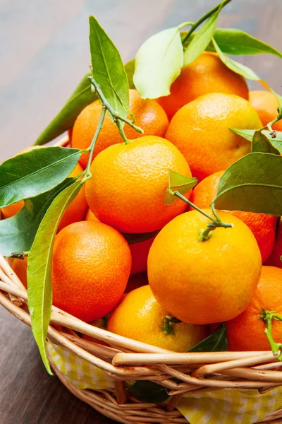 Verse mandarijn sinaasappelen fruit met bladeren op houten tafel — Stockfoto