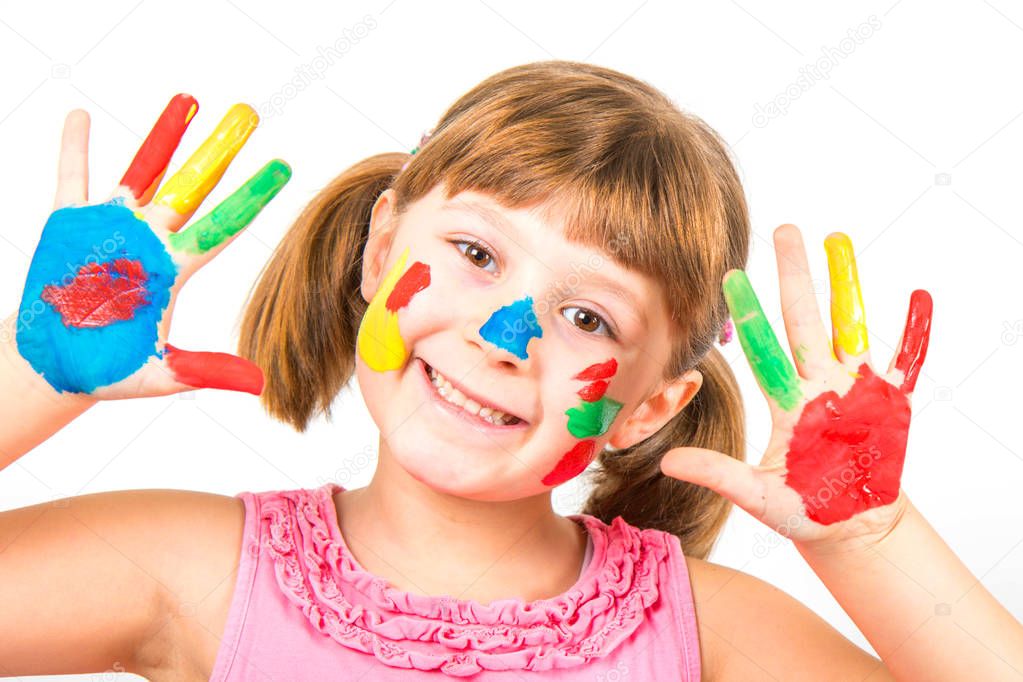 smiling little girl with hands painted in colorful paints