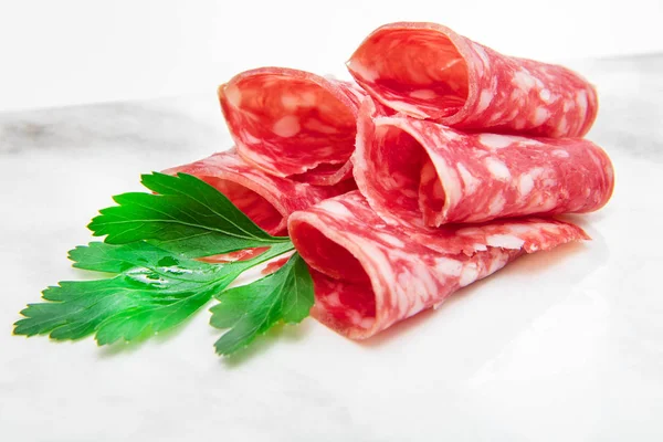 Marble dish with salami slices — Stock Photo, Image