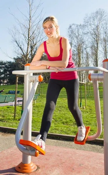 Retrato de mujer alegre en ropa de fitness haciendo ejercicio con equipar —  Fotos de Stock