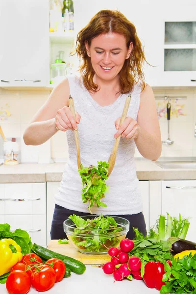 Великолепная женщина смешивает салат на кухне — стоковое фото