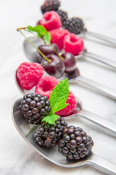 Frische Beeren Auf Stahllöffeln Auf Weißem Marmorhintergrund — Stockfoto