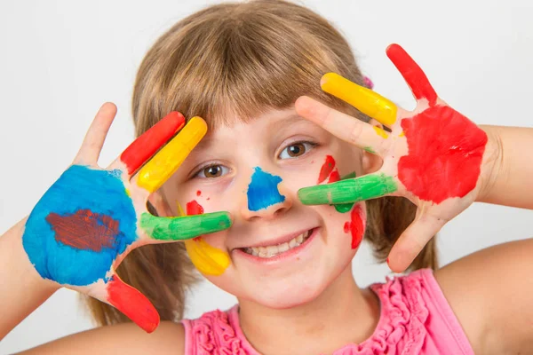Niña sonriente con las manos pintadas en pinturas de colores — Foto de Stock
