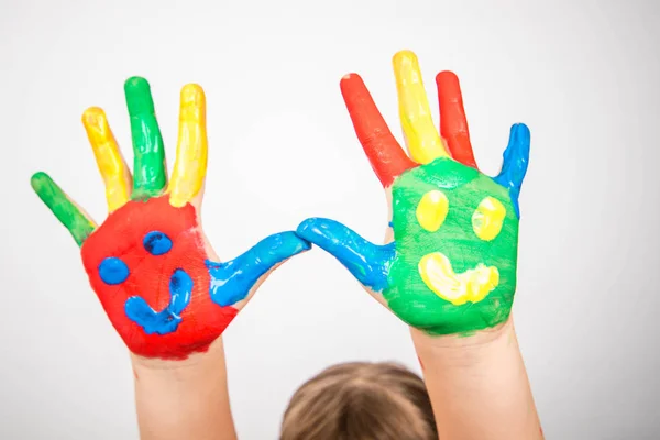 Kinderhände in bunter Farbe mit einem Lächeln — Stockfoto