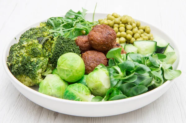vegan dish with soy meatballs and green vegetables