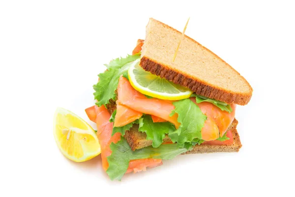 Сэндвич с копченым лососём, салатом и лимоном — стоковое фото