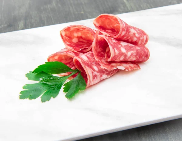 Plat en marbre avec des tranches de salami — Photo