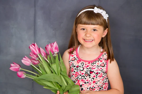 Усміхнена Маленька Дівчинка Букетом Рожевих Тюльпанів Руці — стокове фото