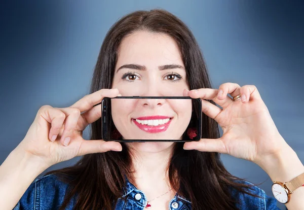 Woman with smartphone that takes a picture of her smile — Stock Photo, Image