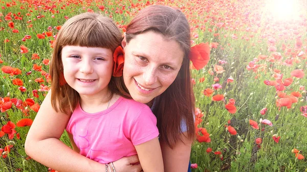 Mother and daughter into a field of poppies — Stock Photo, Image